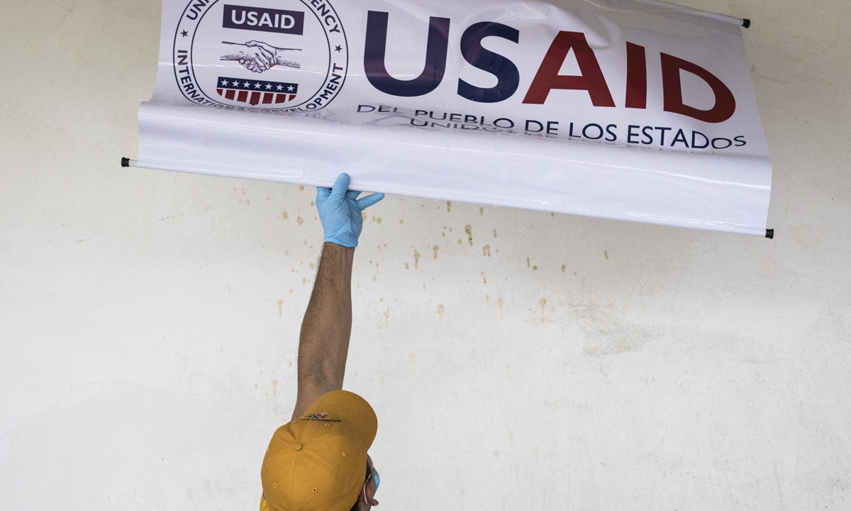 A staff is taking off a sign of the USAID in a community in Cucuta, Colombia, on February 9, 2019. Photo: AFP A staff is taking off a sign of the USAID in a community in Cucuta, Colombia, on February 9, 2019. Photo: AFP