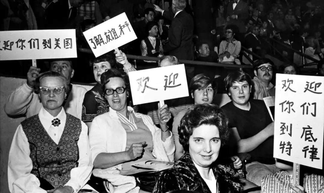 ▎1972年4月,中美两国乒乓球运动员在底特律举行比赛时,看台上的美国观众举着用中文写的标语牌,欢迎中国乒乓球代表团访问美国。图源:中国日报 ▎1972年4月,中美两国乒乓球运动员在底特律举行比赛时,看台上的美国观众举着用中文写的标语牌,欢迎中国乒乓球代表团访问美国。图源:中国日报