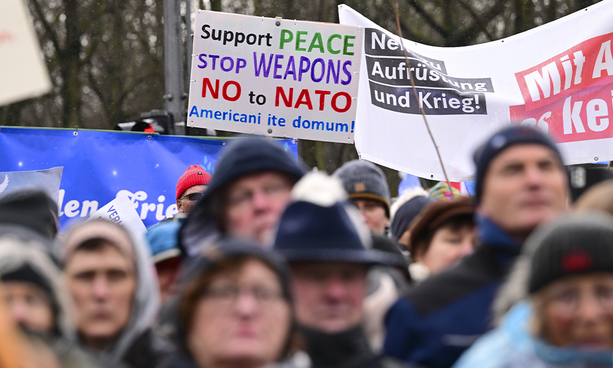 People demonstrate at Brandenburg Gate holding placards against Western arms supplies to Ukraine, calling for peace negotiations of regional conflicts on February 25, 2023 in Berlin, Germany. Photo:IC